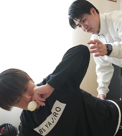 横向きに寝た状態で施術者が身体をサポートする様子